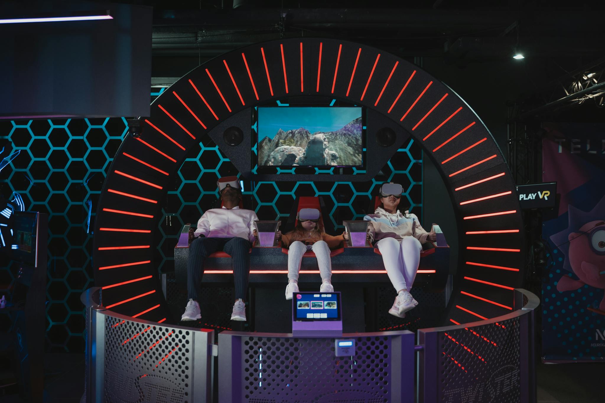Three people enjoying virtual reality gaming in an indoor arcade setting.